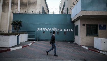 Homem caminha em frente ao prédio da Agência de Assistência e Obras das Nações Unidas (UNRWA) na Cidade de Gaza Ali Jadallah/Agência Anadolu via Getty Images